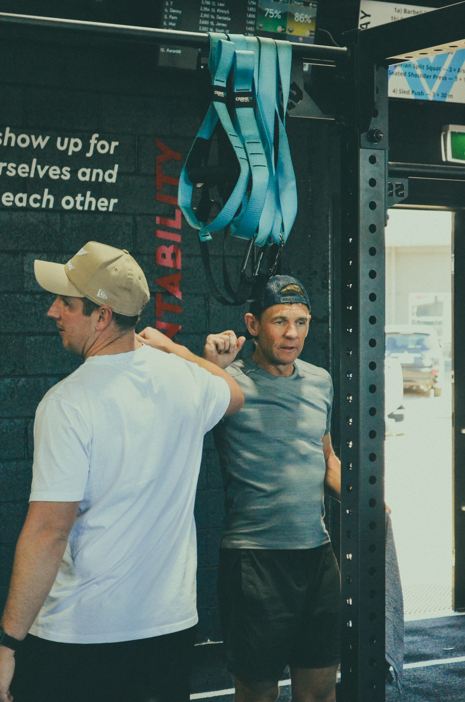A trainer guiding a member during strength training at Pinnacle
